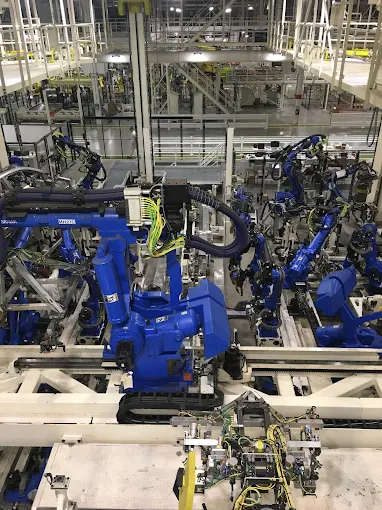 Robotic arms assembling parts in a manufacturing plant.
